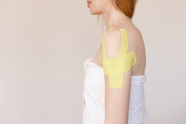 woman with body tapes on her shoulder - Foto, afbeelding