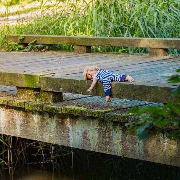 Muñeca se encuentra en el parque en el puente en el parque. Concepto de cuidado infantil. - Foto, imagen