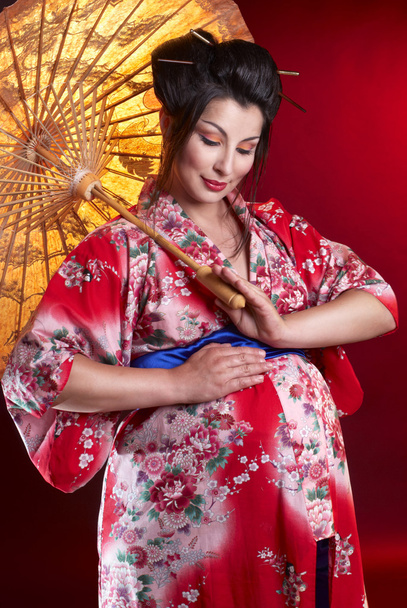 Beautiful pregnant geisha with umbrella - Photo, Image