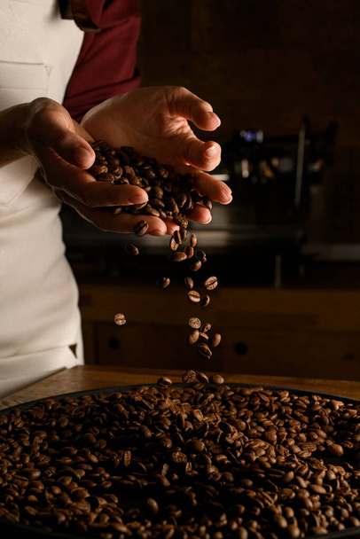 excellent view of female hands with roasted coffee beans pouring out of cupped hands - Zdjęcie, obraz