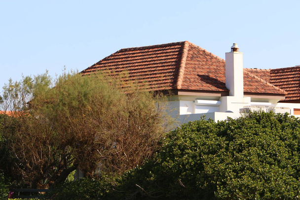 El techo de la casa está hecho de tejas rojas. Detalles arquitectónicos de la construcción de viviendas en Israel.  - Foto, imagen