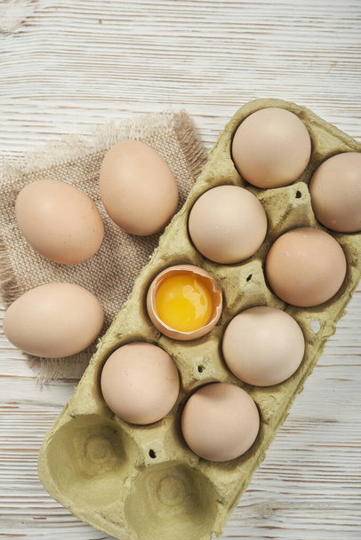Vista de perto dos ovos crus de galinha na caixa de ovos no fundo de madeira. Ovos de galinha crus em ovo caixa alimentos orgânicos para boa saúde alta proteína . - Foto, Imagem