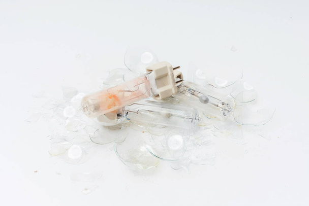 Broken light bulbs on a white background. Burned out broken light bulbs. Details of the crash light bulb for the spotlight close-up - Photo, Image