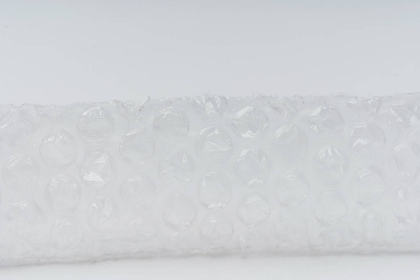 Embrulhe bolha em um fundo branco close-up. Filme para embalagem de bens e objectos frágeis - Foto, Imagem
