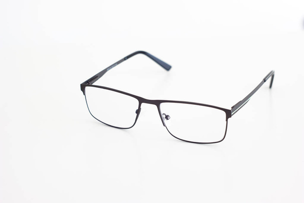 Przezroczyste szklane okulary z cienką metalową ramą zbliżenie strzał izolowany na białym tle płytkiej głębi ostrości. - Zdjęcie, obraz