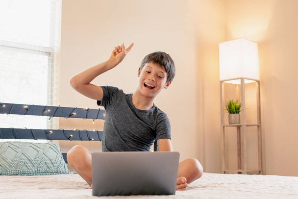 Distance learning online education. Schoolboy studies at home and does school homework. Concept of home education and distance learning. Boy resting and watching a movie in his free time. - Foto, afbeelding