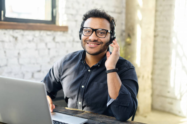 Helpful and friendly mixed-race male employee wearing headset - Photo, Image