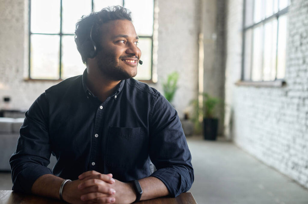 Indian guy using headset in modern office - Foto, immagini