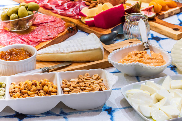 Different types of cheeses, wines, baguettes, fruits and snacks on the table for tasting and holiday scenery. - Foto, Bild