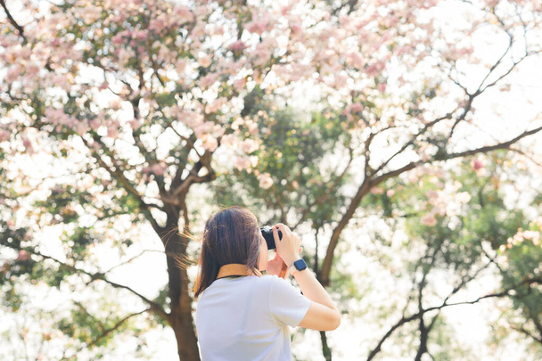 азиатская женщина расслабиться и сфотографироваться розовый цветок вишни в весенний сезон - Фото, изображение