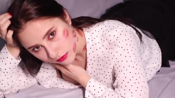 sexy brunette vrouw met kussen, lippenstift markeringen op haar gezicht en nek, met rode roos. vriendin, datum, relateren - Video