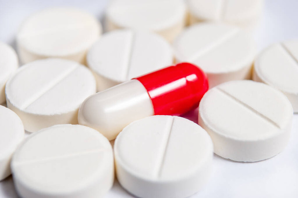 Macro fotografie van witte pillen en coclor capsule op witte achtergrond. Farmacalogisch concept - Foto, afbeelding