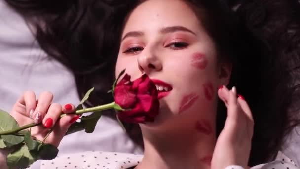 sexy brunette woman with kisses, lipstick marks on her face and neck, with red rose. girlfriend, date, relashionship - Footage, Video