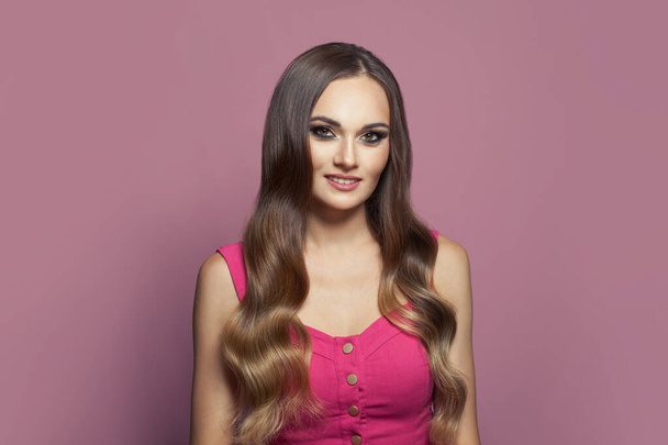 Mulher modelo de moda glamourosa com cabelo longo e saudável e pele clara no fundo rosa - Foto, Imagem
