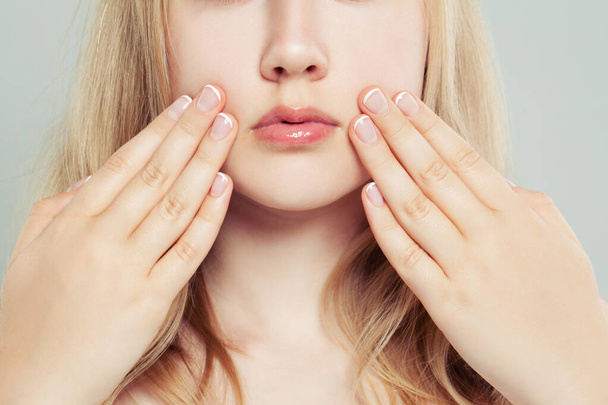French manicure. Woman touching her face her hand with manicured nails - Foto, afbeelding