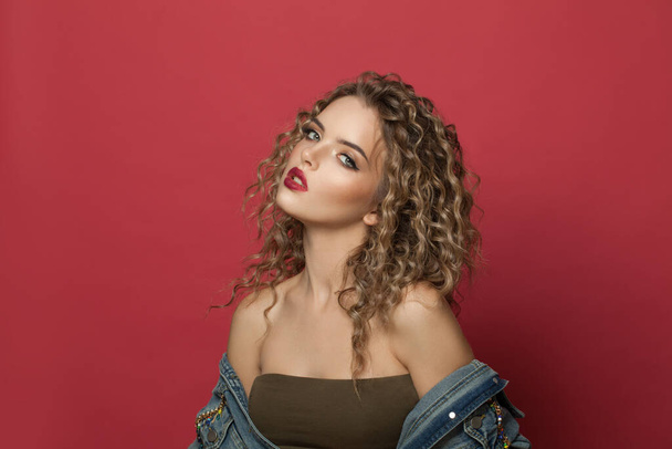 Nice woman with curly hairstyle on red background - Foto, Imagem