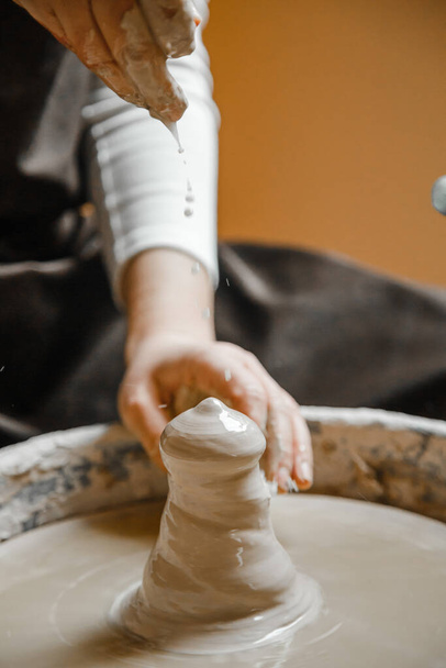 Potter menina esculpe copo de barro na roda do oleiro. Oficina de cerâmica à tarde - Foto, Imagem