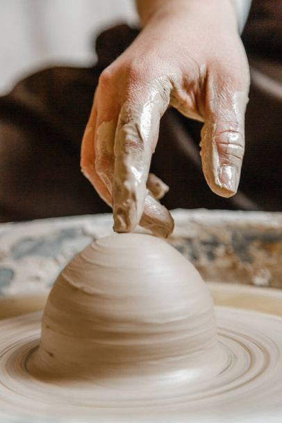 Potter niña esculpe taza de arcilla en la rueda de alfarero. Taller de cerámica por la tarde - Foto, Imagen