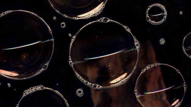 Zeepbellen schuim op glazen oppervlak geïsoleerd op zwarte achtergrond. Licht in de donkere nacht. Abstracte verlichting. Nachtclub abstract Behang - Foto, afbeelding