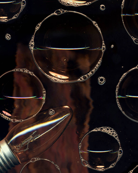 Jabón burbujas de espuma en la superficie de vidrio aislado sobre fondo negro. Luz en la noche oscura. Decoración de iluminación abstracta. Club nocturno abstracto Fondo de pantalla - Foto, imagen