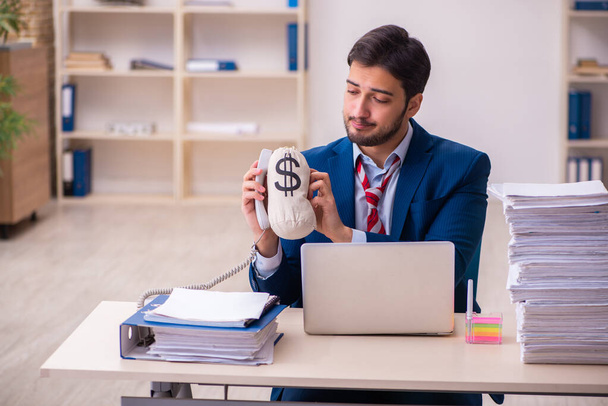 Молодой бизнесмен недоволен чрезмерной работой в офисе - Фото, изображение