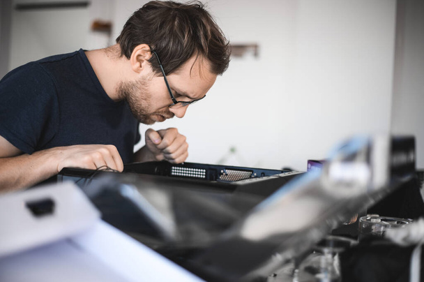 portrait of a handsome nerd man is servicing Computer motherboard and cooler. - Photo, Image