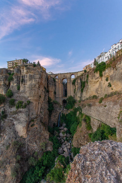 Medieval aqueduct between two cliffs in a village. Ronda in Spain - Photo, Image