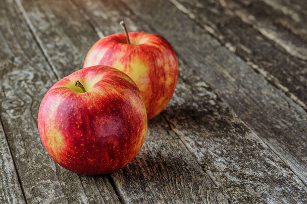 Green and red apples on blackboard or chalkboard background. Bright fruit composition.Red and green apple on old wooden table. Top view with space for your text - 写真・画像