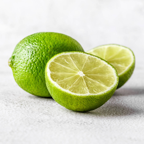 Green lime with cut in half and slices isolated on white background.Healthy green foods - alternative medicine involve a balanced diet with vitamins, nutritions and superfoods for human well-being. - Zdjęcie, obraz