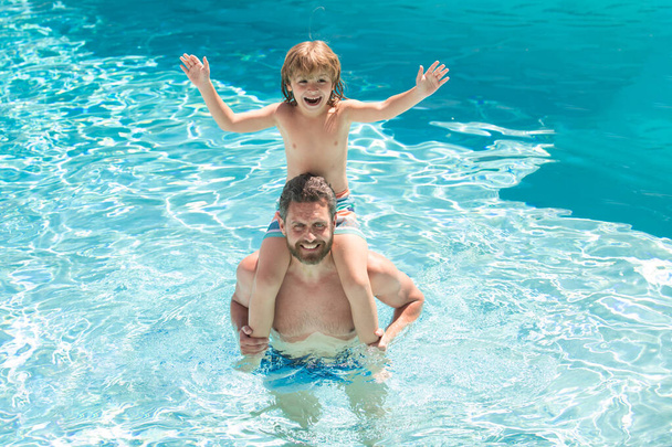 Fathers piggyback ride child in swimming pool. Active leisure. - 写真・画像