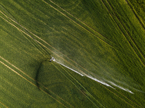 Farmland from above - aerial image of a lush green field being irrigated - Photo, image