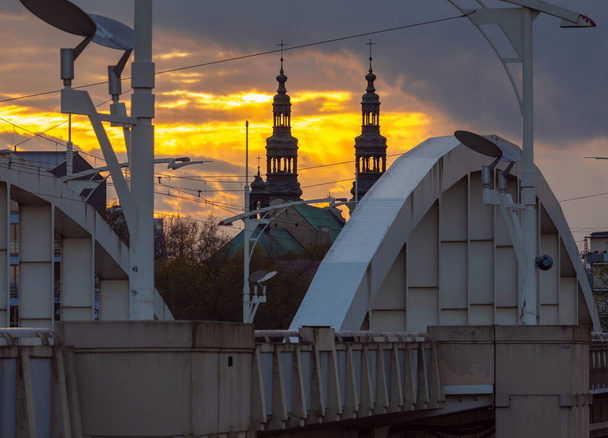 Poznan. Die Brücke von St. Rochus und der Kirchturm bei Sonnenuntergang. - Foto, Bild