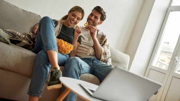 Picture of a young couple watching sitcoms at home  - Foto, Bild