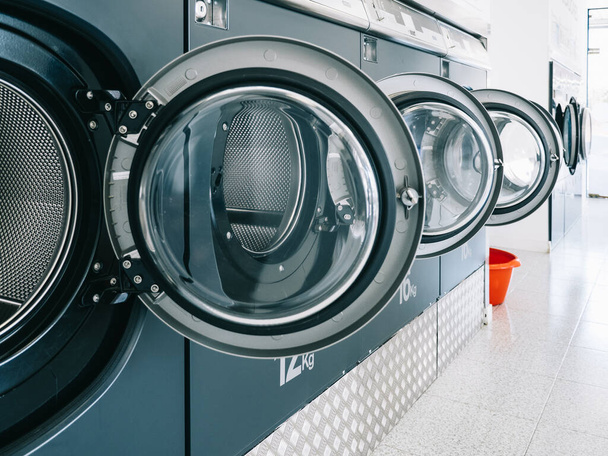 Row of washing machines in a public laundromat. Cleaning concept - Photo, Image