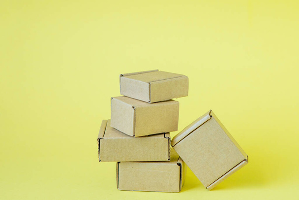 Cardboard boxes of various sizes on yellow background - Foto, Imagem