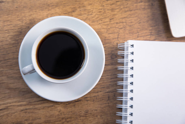 notepad with cup of coffee on tabl - Φωτογραφία, εικόνα
