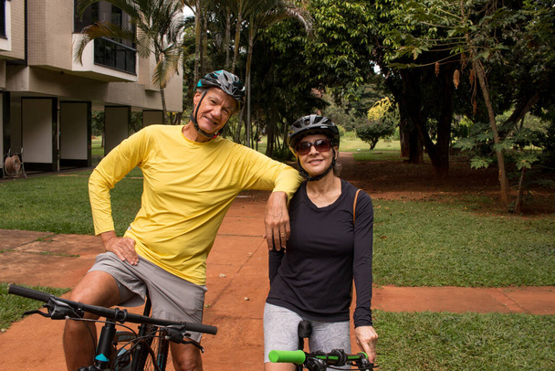Couple d'âge mûr en plein air dans une zone urbaine sur leurs vélos - Photo, image