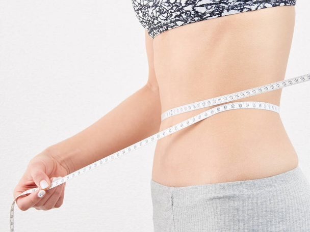 Asian woman measuring waist size - Photo, Image