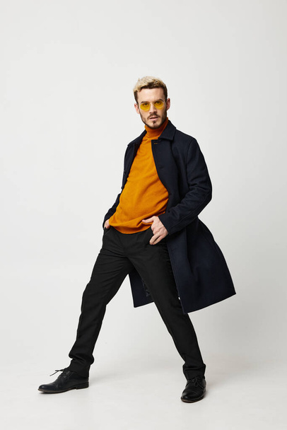 handsome guy in a sweater unbuttoned coat pants emotions model - Foto, Imagem