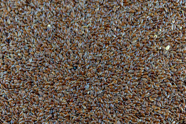 Linum usitatissimum seed background. Flaxseed is the seed of flax, widely used in cooking. Food rich in fiber, fatty acids and protein. - Photo, Image