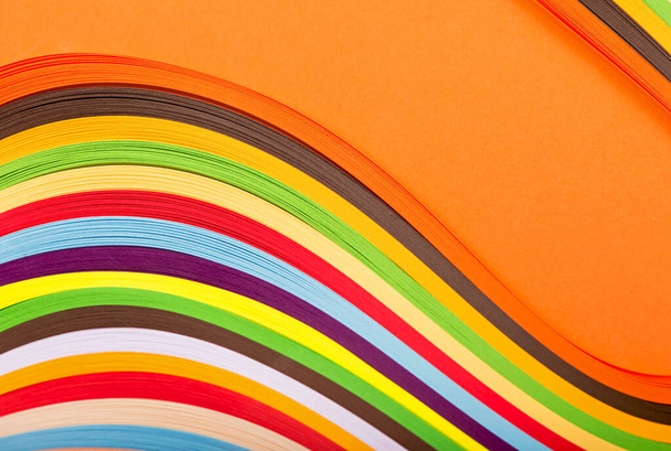 curl rainbow strip paper on orange background. - Foto, Imagem