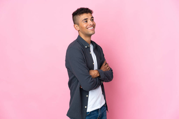 Молодой бразилец изолирован на розовом фоне счастливый и улыбающийся - Фото, изображение