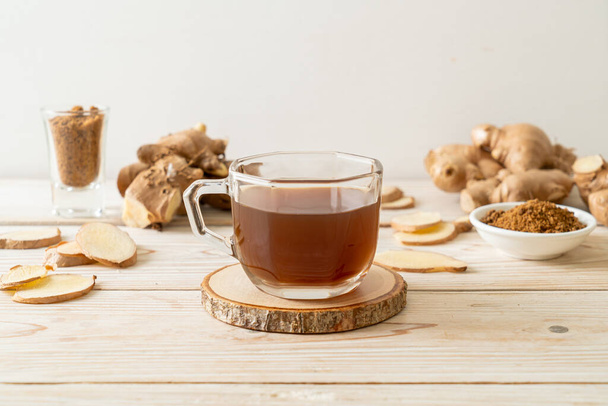 hot and sweet ginger juice glass with ginger roots - Healthy drink style - Zdjęcie, obraz