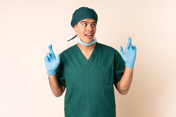 Kirurgi sininen univormu yli eristetty tausta sormet ristissä - Valokuva, kuva