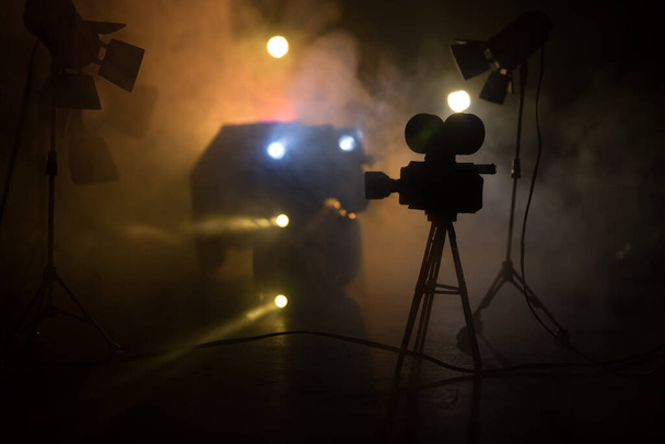 Actiefilm concept. Politieauto 's en miniatuurfilm op donkere achtergrond met mist. Politieauto die 's nachts een auto achtervolgt. Plaats van het misdrijf ongeluk. Selectieve focus - Foto, afbeelding