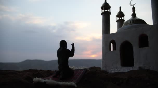 Ramadan Kareem background. Realistic mosque miniature with prayer silhouette. Selective focus - Imágenes, Vídeo