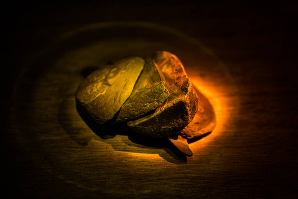 Parts of broken stone on a wooden table. Colorful lights on stones in selective focus. Close up - Фото, изображение