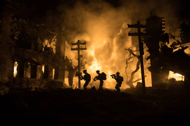 Sota-ajatus. Sotilaallinen siluetit taistelevat kohtaus sodan sumu taivaalla tausta, maailmansodan sotilaat siluetti alla pilvinen Skyline yöllä. Taistelu raunioituneessa kaupungissa. Valikoiva painopiste - Valokuva, kuva