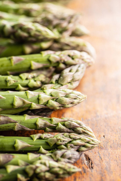 Fresh raw uncooked green asparagus on wooden table. - 写真・画像