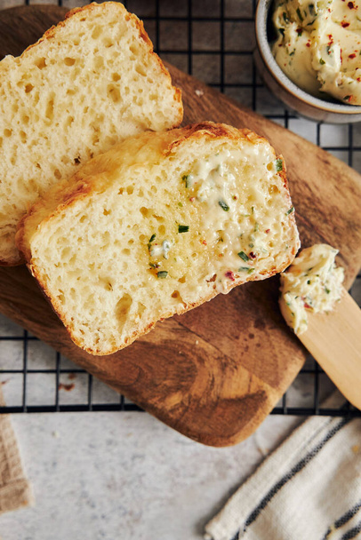 A closeup shot of delicious cheese bread with herb butter on a white table - Foto, Bild